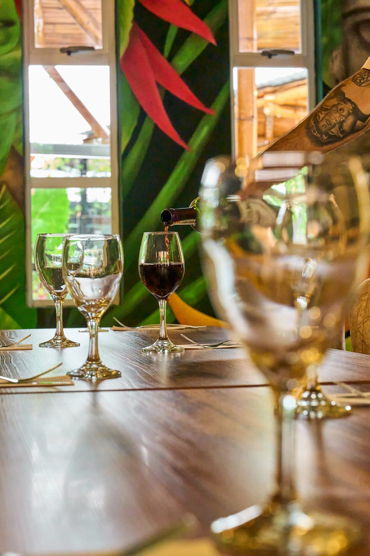 Servicio de vino frente al mural tropical