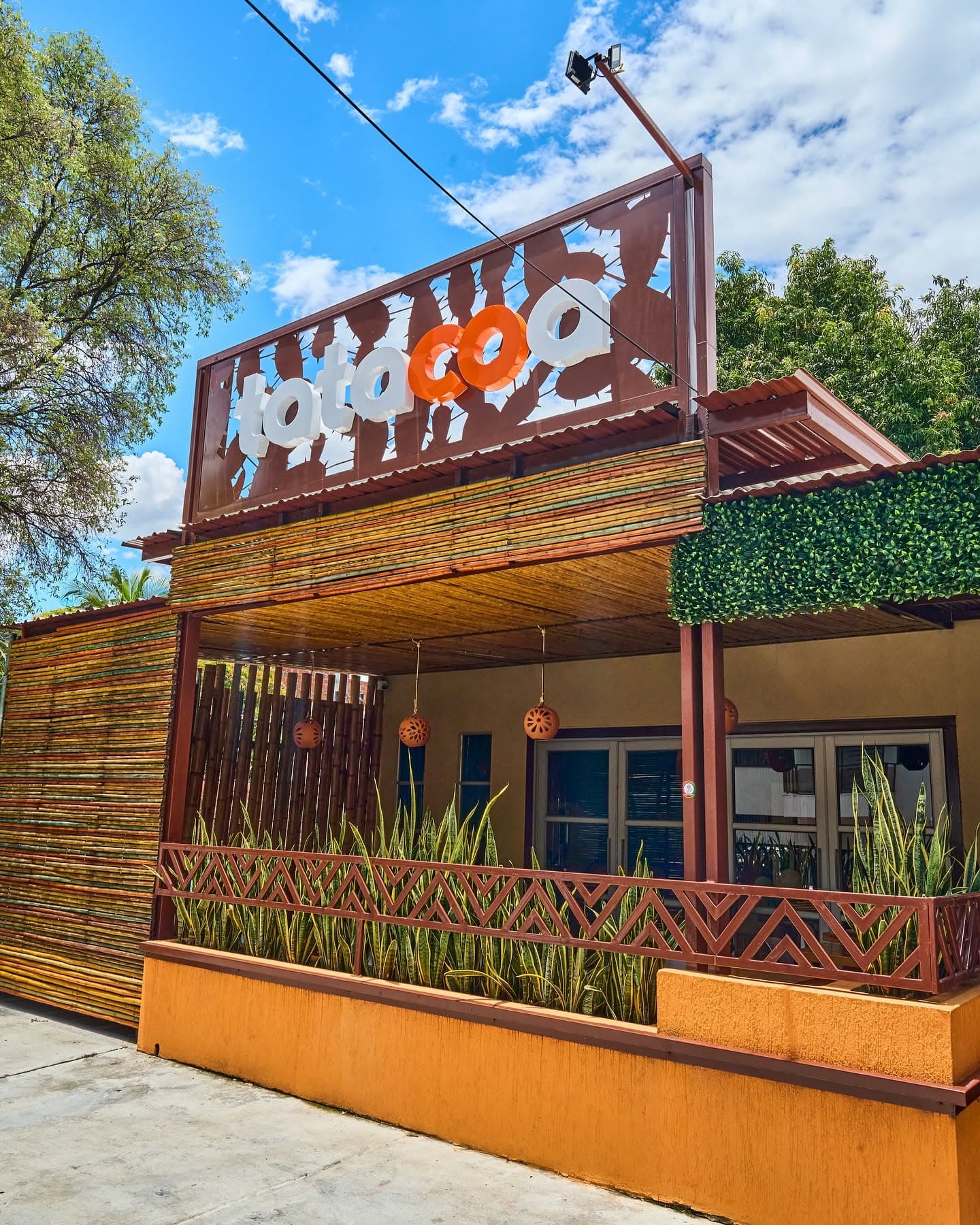 Terraza exterior de Tatacoa con letrero y plantas