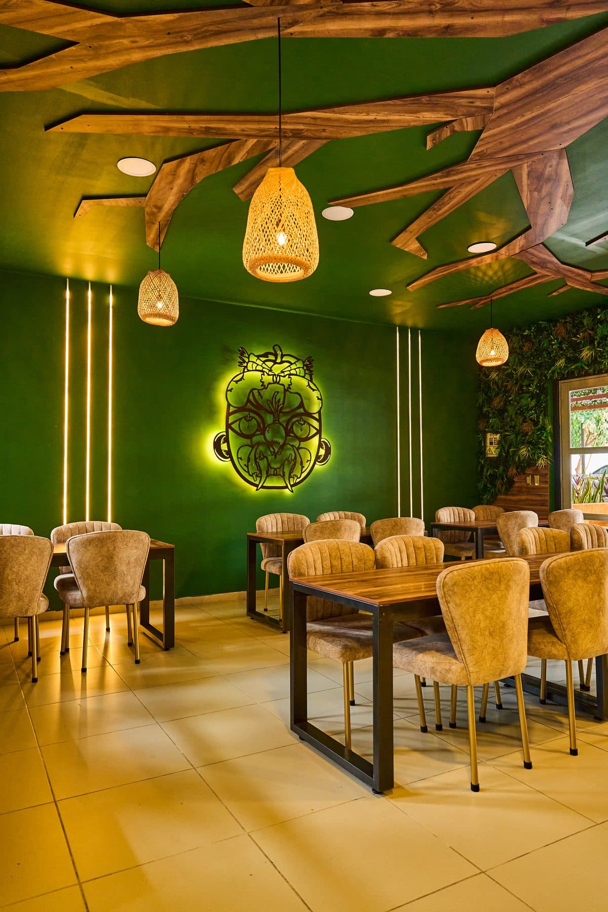 Sala interior con logo Tatacoa, lámparas de mimbre y pared verde